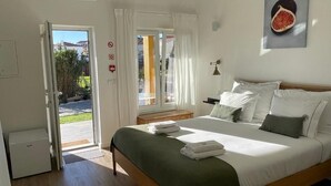 Een slaapkamer met een bed, nachtkastje, lamp en raam.