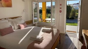 Een hotelkamer met een bed, een raam, een deur en uitzicht op buiten.