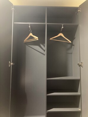 Ein Kleiderschrank mit zwei Holzprogrammen und mehreren Einlegeböden.