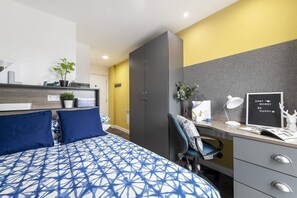 Ein modernes Schlafzimmer mit Bett, Schreibtisch, Kleiderschrank und einem motivierenden Bild.