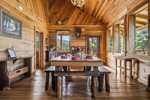 A wooden cabin interior with a large dining table, benches, and a rustic ceiling. - New Listing, Hot Tub, Game Room, Relaxing Outdoor Space, Putting Green (Sevierville)