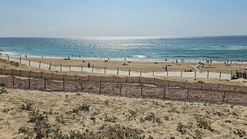 Une plage avec une zone de sable et une partie délimitée par une clôture.
