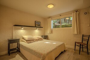 A bedroom with a bed, bedside tables, a chair, a window with curtains, and a picture on the wall. - Between the ocean and the Bassin, near the tip, house with large garden (Lège-Cap-Ferret)