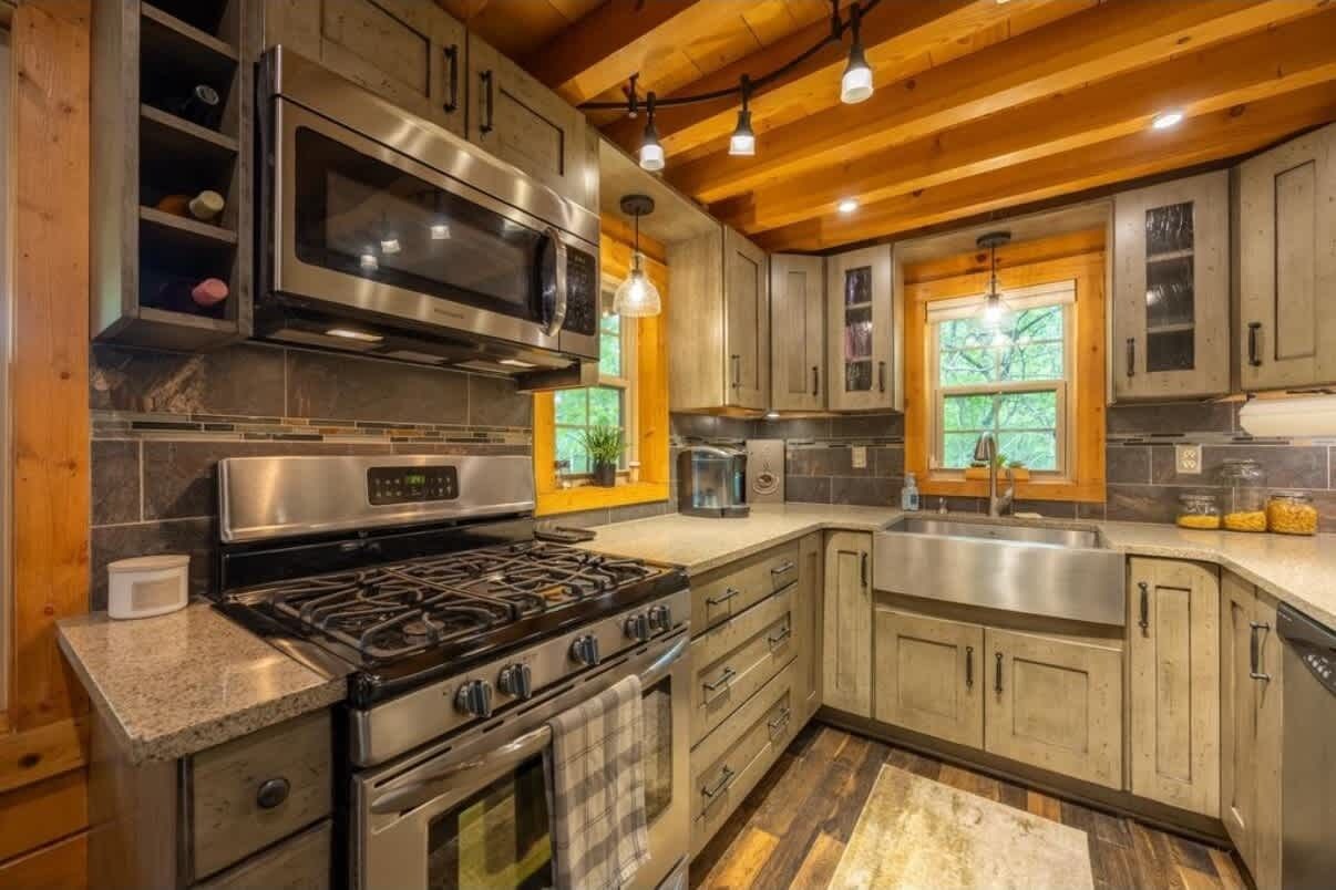 A modern kitchen with stainless steel appliances, wooden cabinets, and a central island.