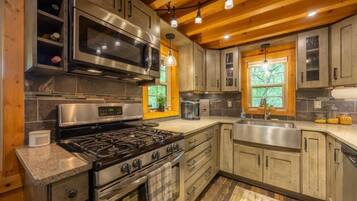 A modern kitchen with stainless steel appliances, wooden cabinets, and a central island.