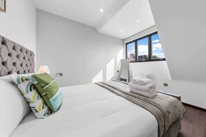 Ein modernes Schlafzimmer mit einem großen Bett, einem Fenster mit Blick und einer eingebauten Heizung.