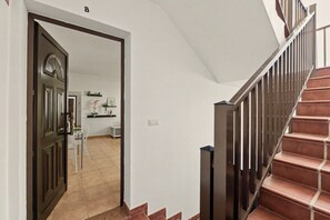 Eine Treppe mit Metallgeländer und einem mit Braunem Teppich belegten Podest.