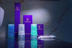 A collection of toiletries with the ViTash Inn logo, including a shower gel, body lotion, shaving kit, and shampoo.