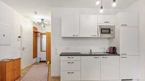 Eine moderne Küche mit weißen Schränken, einer Mikrowelle und einer Kaffeemaschine.