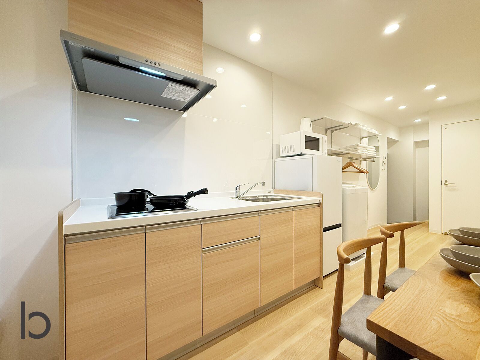 A modern kitchen with a stove, sink, and white cabinets.