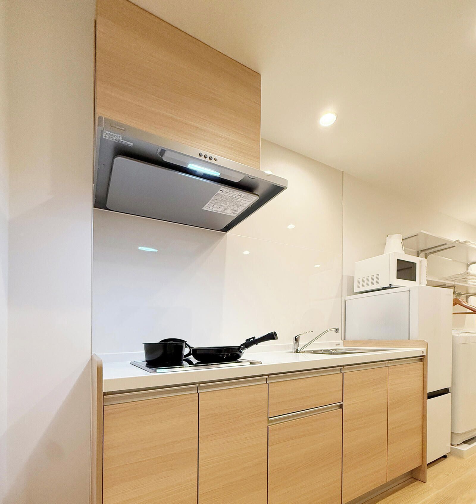 Una cocina moderna con estufa integrada, un microondas y un refrigerador.