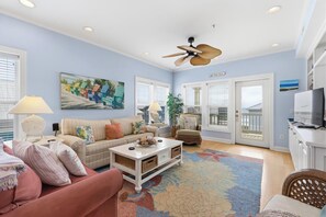 A living room with a sofa, armchairs, a coffee table, a TV, and a ceiling fan. - Big Blue - Second Row Home with Ocean Views! (Carolina Beach)