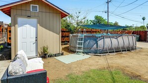 Um pequeno abrigo com porta, piscina coberta e escada.