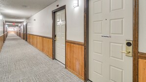 A hotel hallway with wooden paneling, white doors, and a carpeted floor. - < 1 Mi to Granby Rodeo! Retreat w/ Pool & Hot Tub (Granby)