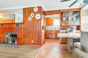 Interior de madera con chimenea, comedor y cocina con armarios de madera.