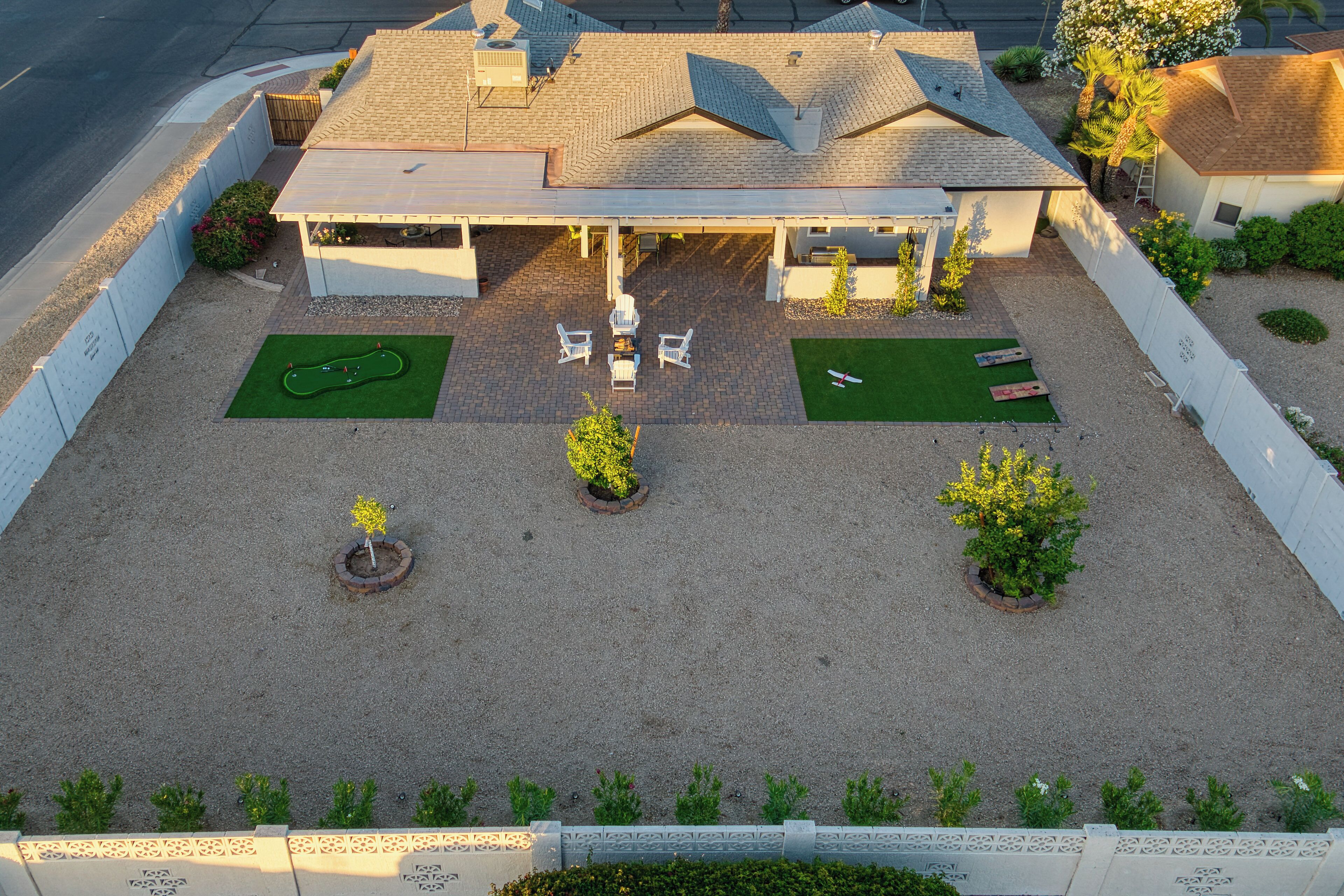 Une maison dotée d’un patio couvert, d’une pelouse et d ’un petit jardin.