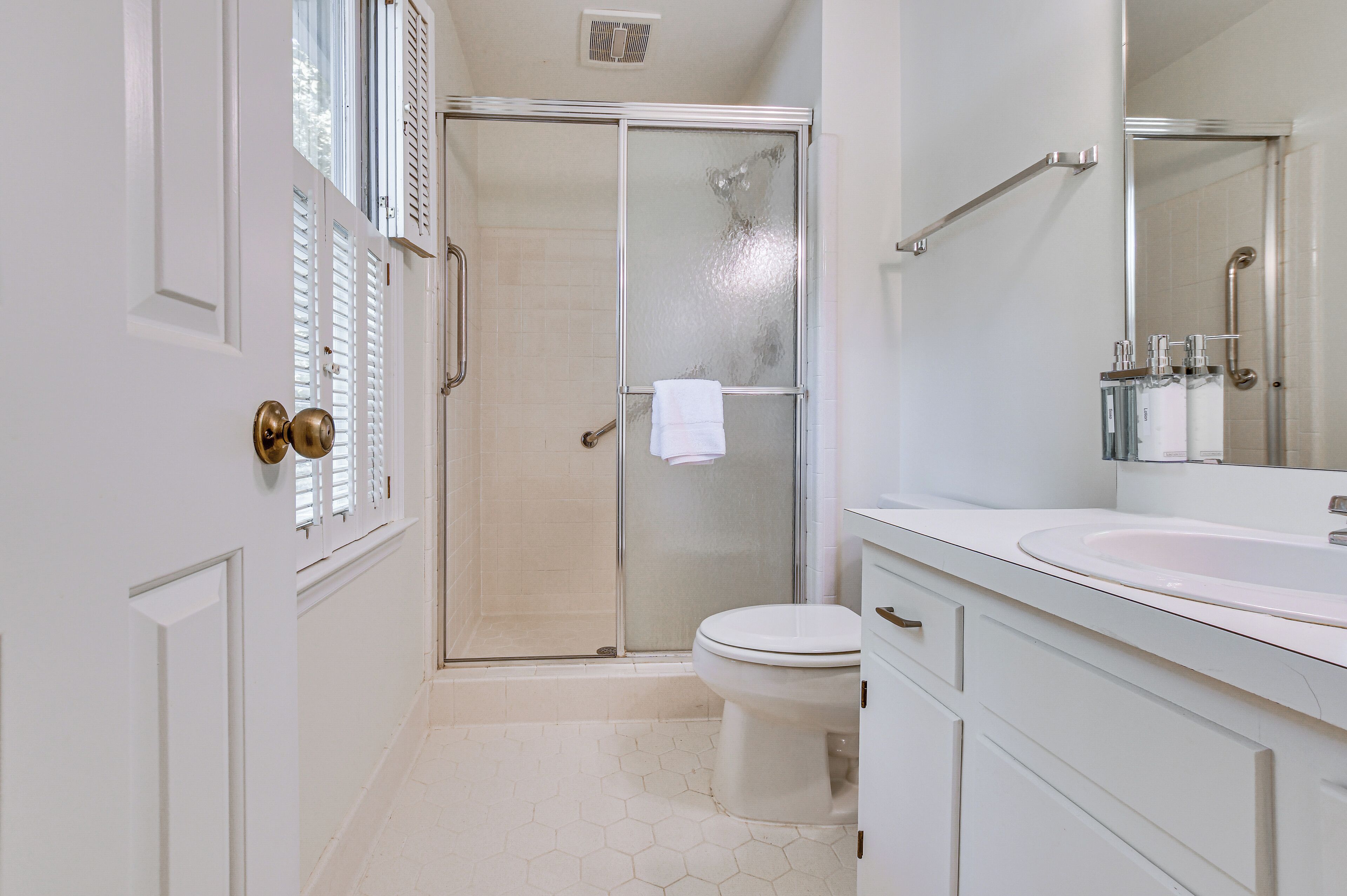 A bathroom with a shower, toilet, and sink.