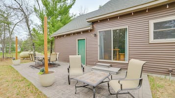 A house with a patio, outdoor furniture, and a large window.