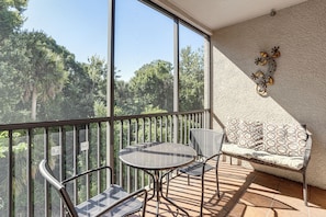 A balcony with a table and chairs, a sofa, and a decorative wall piece. - Disney Magic & Tuscana Resort Fun! Family Condo (Davenport)