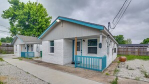 Ein eingeschossiges Haus mit Veranda, einer kleinen angebauten Garage und einem Garten mit Grill.