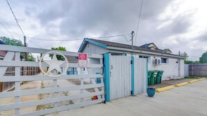 Zona residencial privada con cerco blanco, puerta azul y un letrero que indica 'Tenant Parking Only'.