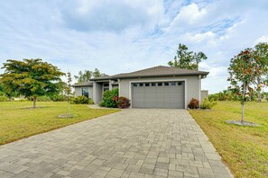 A modern two-story house with a paved driveway, a garage, and landscaped gardens. - Punta Gorda Home: Great for Nurses & Professionals (Punta Gorda)