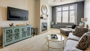 A living room with a flat-screen TV, a fireplace, a sofa, a coffee table, and a ceiling fan. - Easy E470 & 125 Access! Quiet Englewood Condo (Parker)