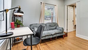 A room with a desk, chair, lamp, sofa, and a door leading to another room. - Walk to Historic Weatherford: Home w/ Yard (Weatherford)