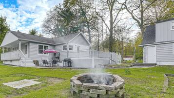 A house with a fire pit, a covered patio, and a deck.