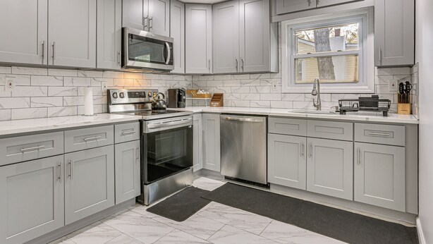 A modern kitchen with grey cabinets, a microwave, oven, and dishwasher. - Deck & Patio! Wurtsboro Haven Near Lakes & Trails (Wurtsboro)