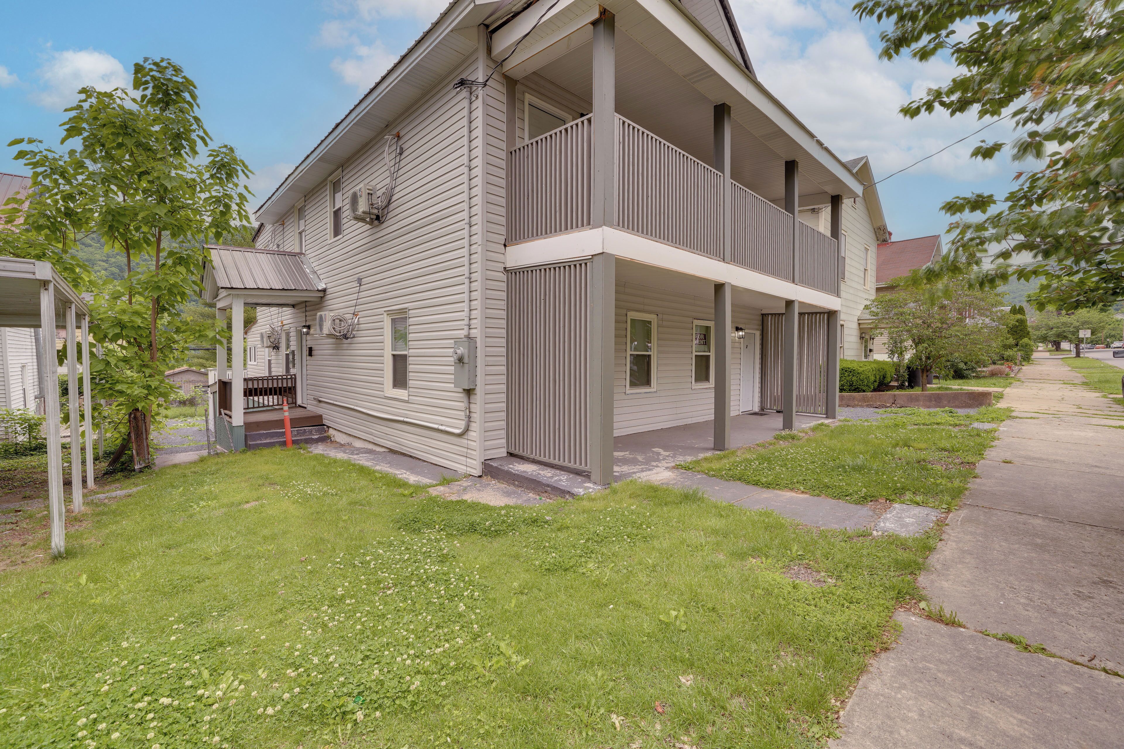A two-story house with a front porch, a covered entryway, and a small front yard.