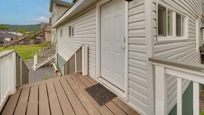 Una casa con porche, puerta principal y un ventanal pequeño.