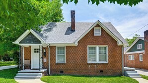 A two-story brick house with a front porch, a chimney, and a well-maintained lawn. - Charlotte Duplex Close to Uptown and Sports (Charlotte)