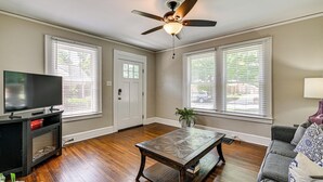 A living room with a ceiling fan, a television on a stand, a coffee table, and a couch. - Charlotte Duplex Close to Uptown and Sports (Charlotte)