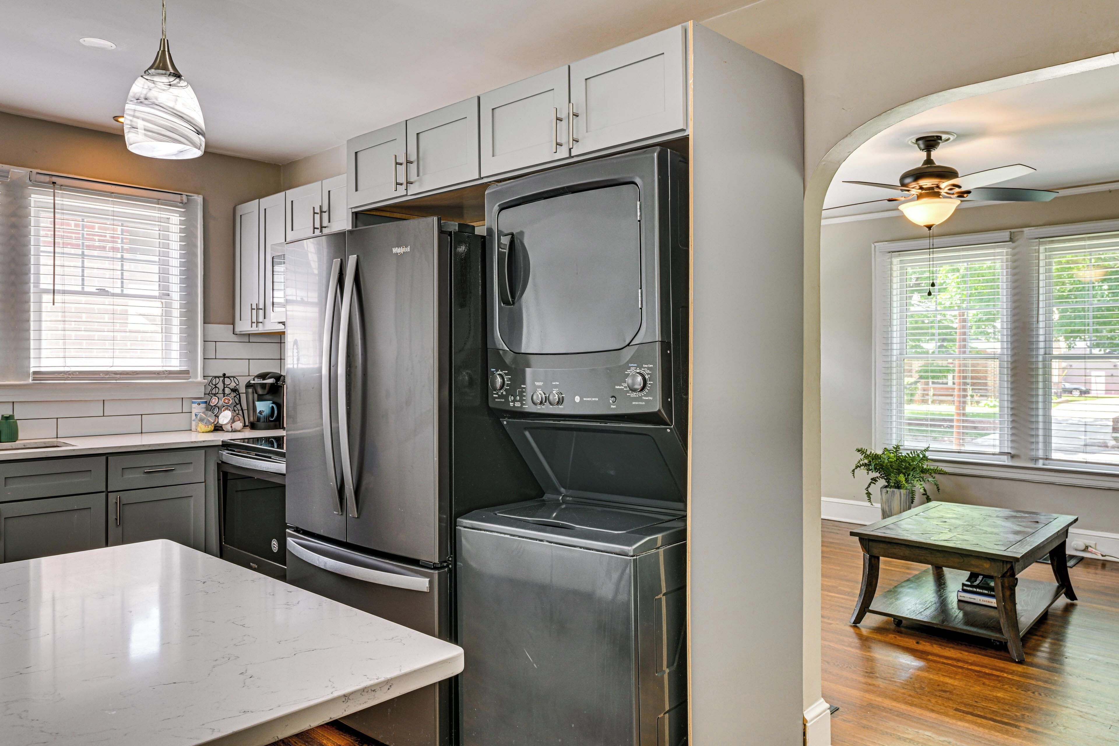 A kitchen with a large refrigerator, a built-in oven, and a ceiling fan.