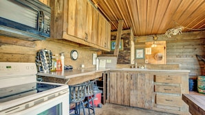 Une cuisine rustique avec des meubles en bois, un poêle et un coin bar.