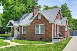 A two-story brick house with a front porch, a chimney, and a small front yard. - Charlotte Duplex Close to Uptown and Sports (Charlotte)