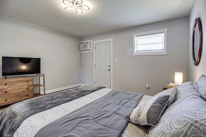 A bedroom with a bed, a dresser, a television, a window, and an air conditioning unit. - 3 Mi to Dtwn: Pet-friendly Studio in Huntsville (Huntsville)