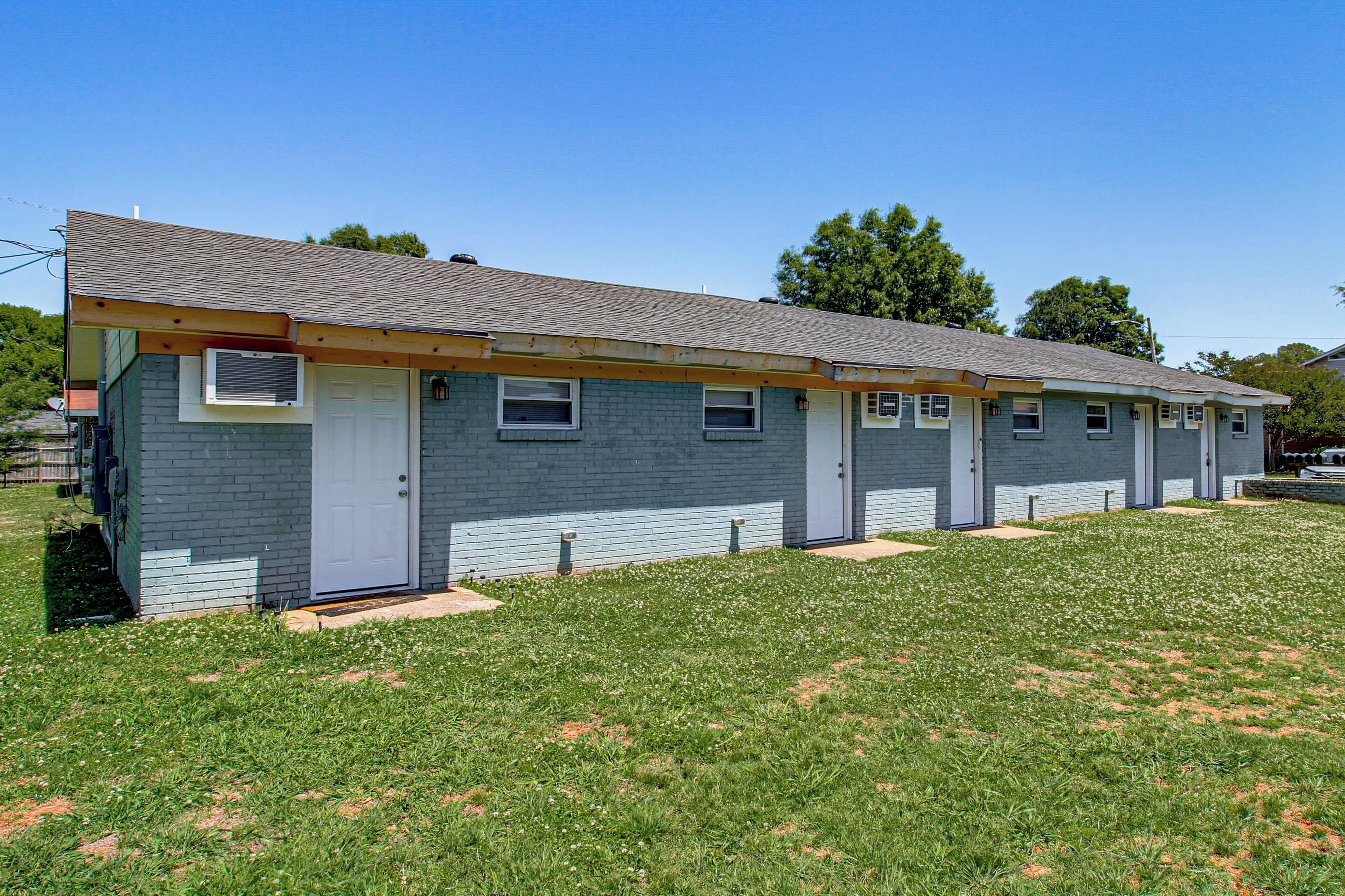 A single-story building with a flat roof, a front door, and a small porch area.