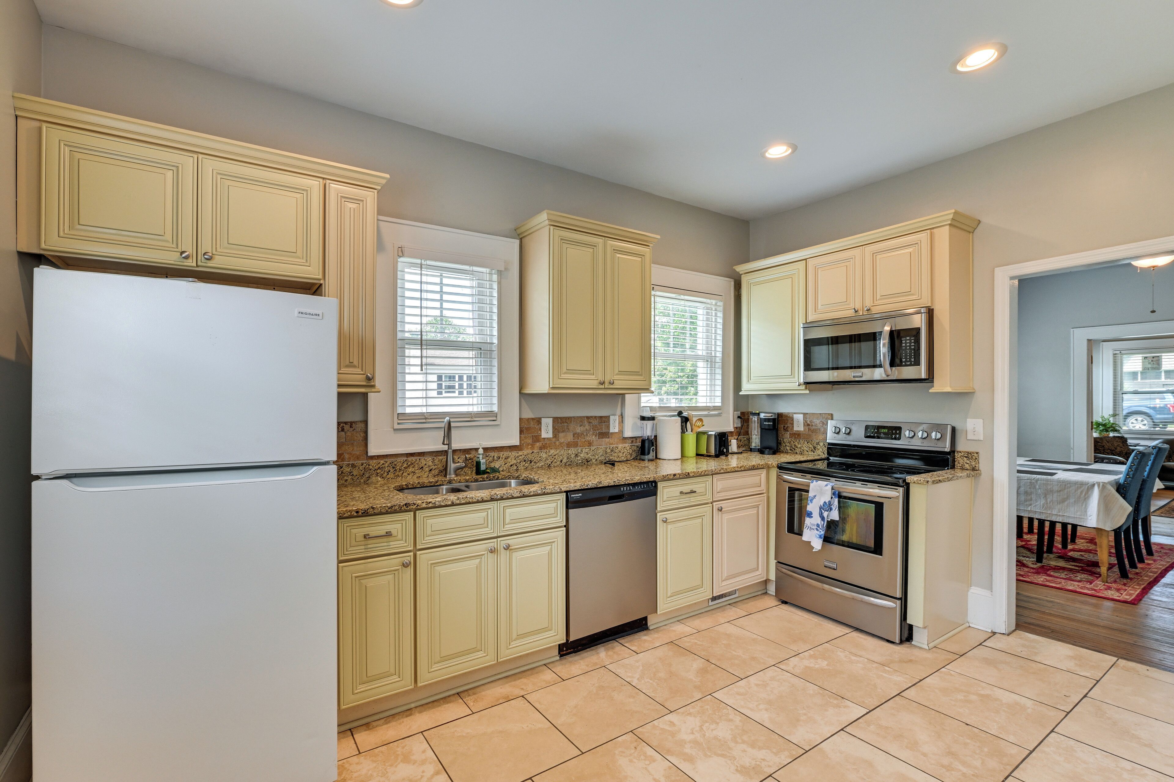 A kitchen with light-colored cabinets, a refrigerator, a dishwasher, a microwave, and an oven.