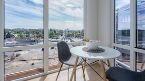 Ein modernes Zimmer mit großen Fenstern, einem runden Tisch und einem Stuhl.