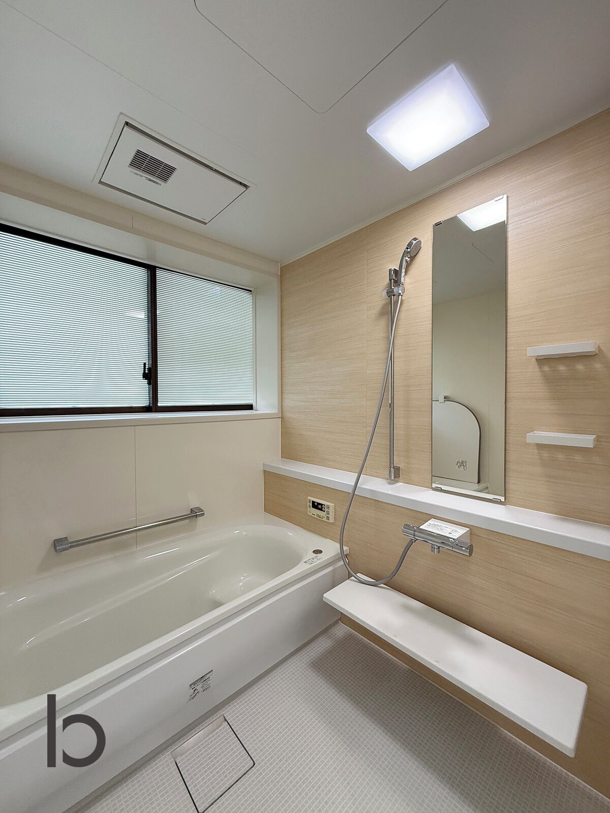Un baño moderno con bañera, ducha, espejo y ventana con persianas.