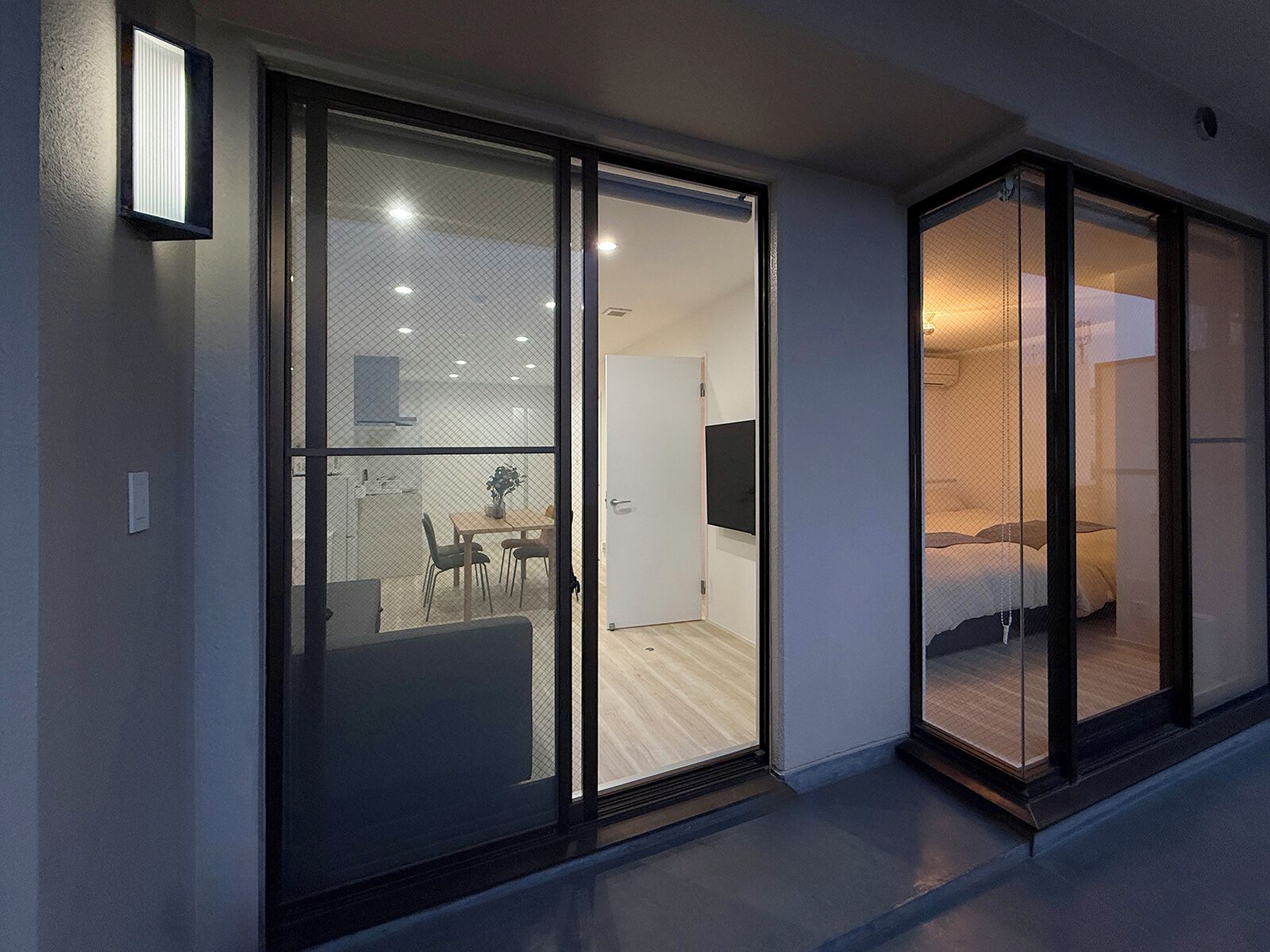 A modern interior with a dining area, a bed, and a TV.