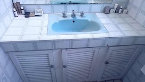 A bathroom with a large sink, two cabinets, and a mirror above the sink. - Room-charming Lodge Room in Sandton With (Johannesburg)