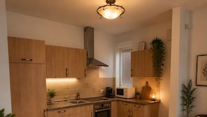 Una cucina moderna con mobili in legno, forno integrato, microonde e macchina da caffè.