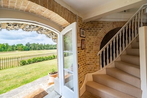 A staircase with a beige carpet, a brick wall, and a white railing. - A Duke's spectacular grand folly -The Temple (Bury St Edmunds)