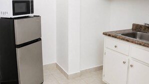 Eine Küche mit Kühlschrank, Mikrowelle und einer Arbeitsplatte aus Granit.