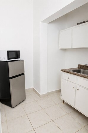 A kitchen with a refrigerator, microwave, and granite countertop. - Spacious 1BR Apt Steps from Beach and Old San Juan (San Juan)