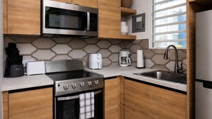 Una cucina moderna con forno a microonde in acciaio inossidabile, forno ventilato, piano cottura e lavello.