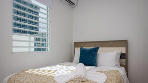 Una camera d'albergo con un letto, una finestra e vista su un edificio.
